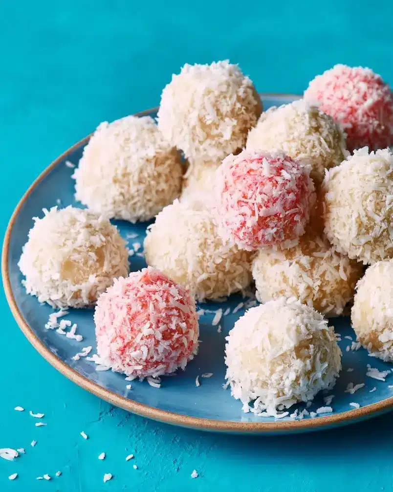 Coconut Cake Snowballs 3 A batch of coconut cake snowballs being rolled in powdered sugar